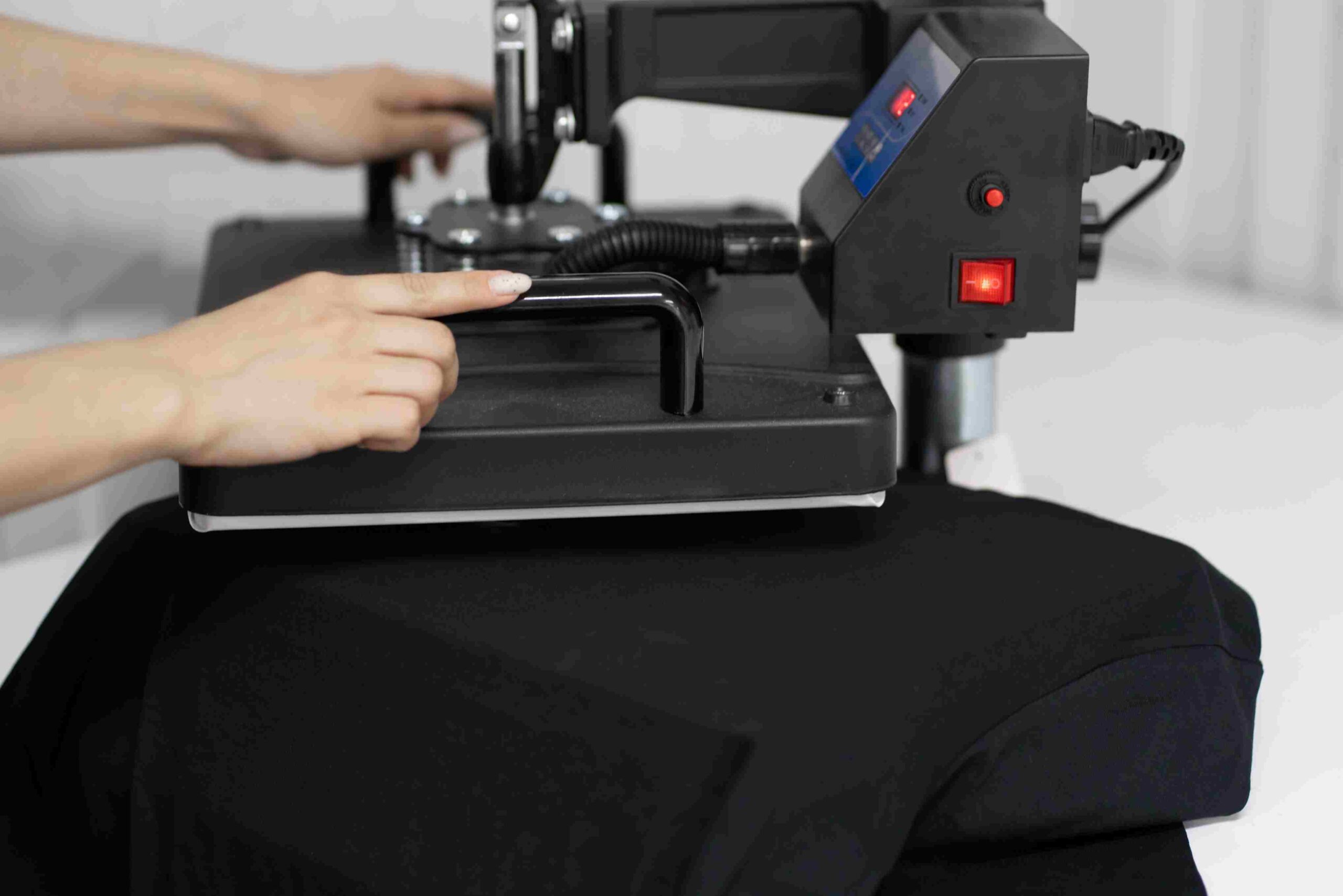 Koja štampa na tekstilu najduže traje - poređenje tehnika štampe u praksi 7 Termo presa u procesu štampe na crnoj majici za personalizaciju tekstila.